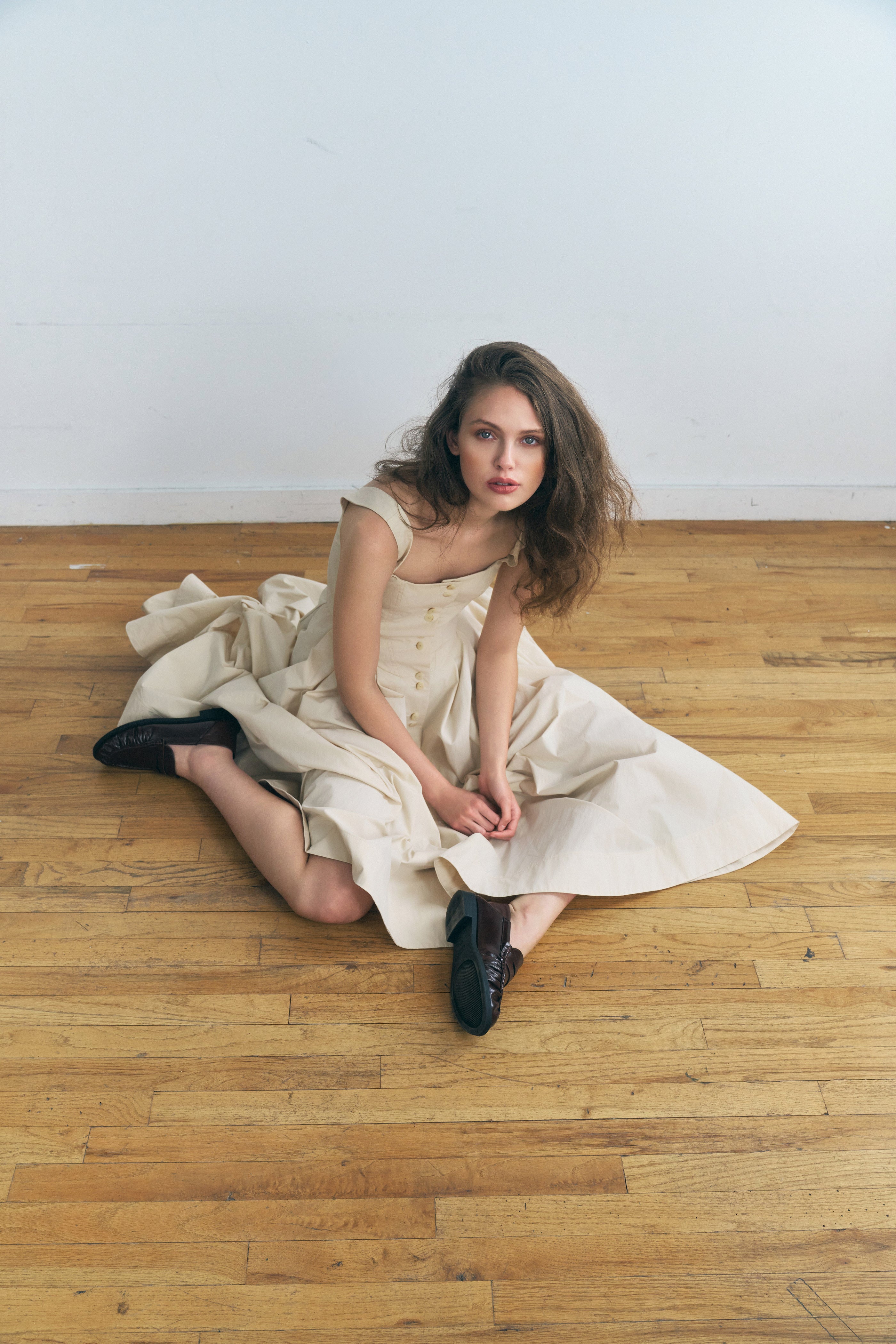 Toloache dress in Powder — Premium Japanese Cotton Blend, seamed bustier bodice, full A-line skirt, Italian carozo natural buttons, concealed back zipper closure, seated on floor lifestyle editorial
