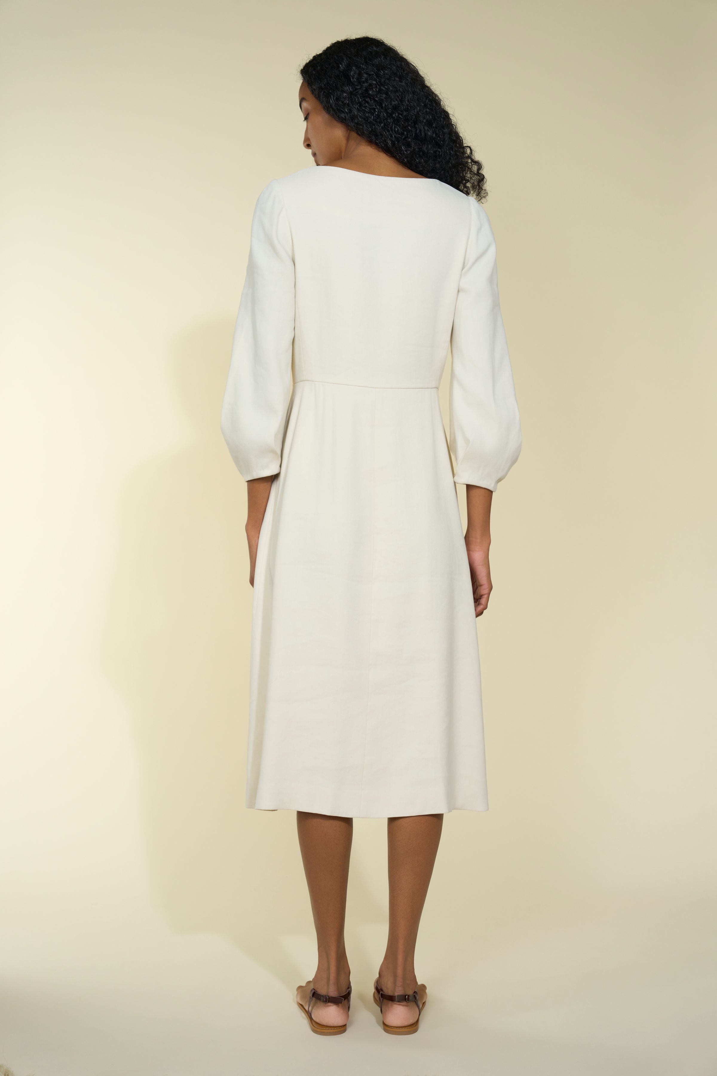 Alamo Dress in Alabaster — sleek Italian linen twill with slight natural stretch, seamed natural waist, sculpted three-quarter sleeves, button-front closure, above-ankle length, back view