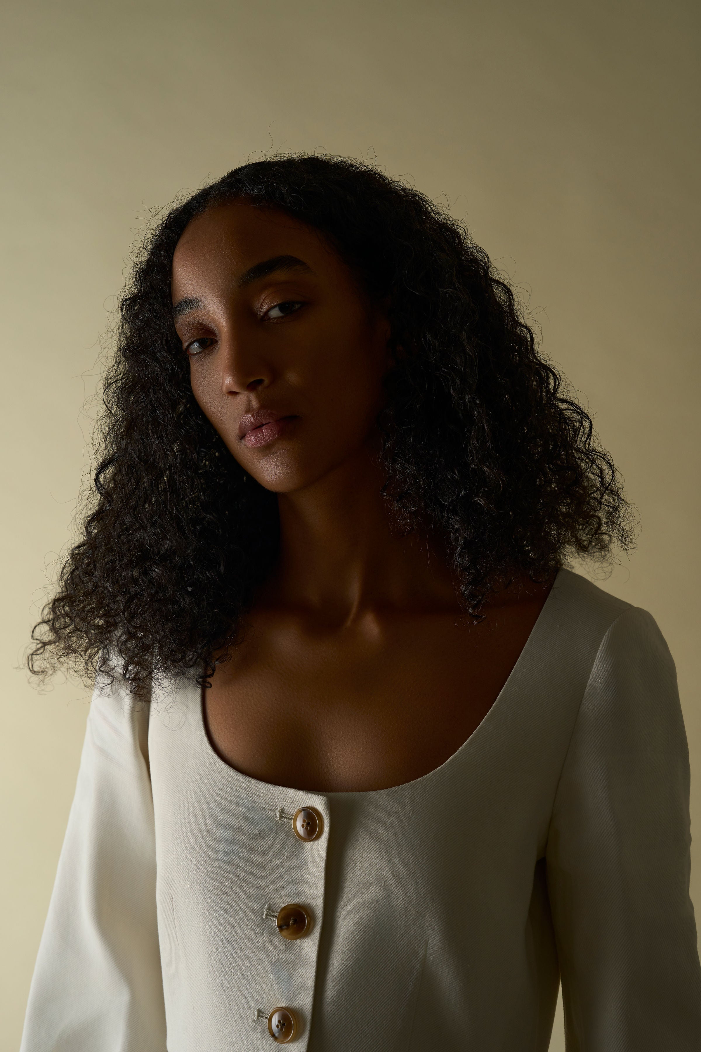 Alamo Dress in Alabaster — sleek Italian linen twill with slight natural stretch, seamed natural waist, sculpted three-quarter sleeves, button-front closure, above-ankle length, lifestyle editorial