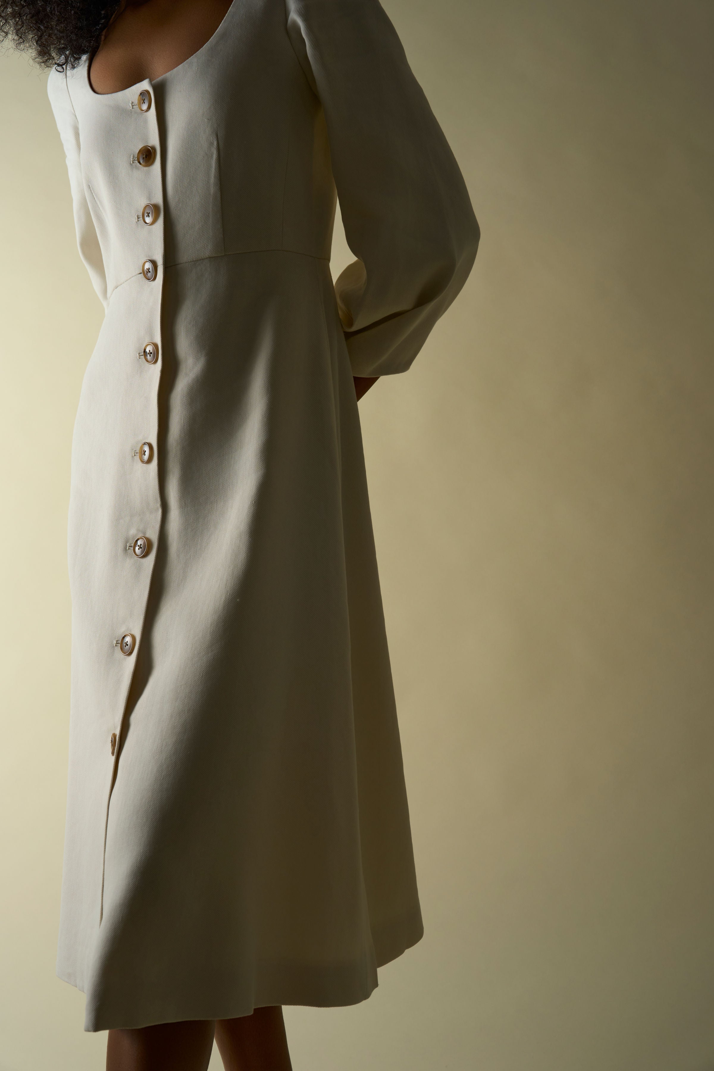 Alamo Dress in Alabaster — sleek Italian linen twill with slight natural stretch, seamed natural waist, sculpted three-quarter sleeves, button-front closure, above-ankle length, side view