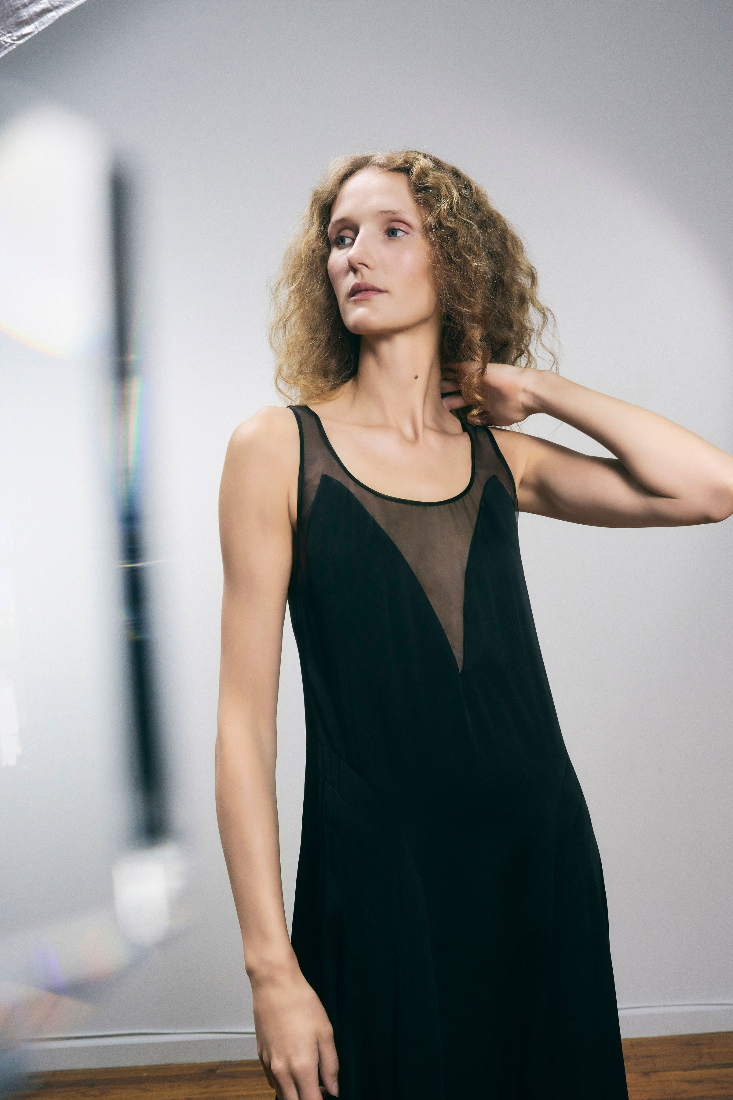 Ceiba Dress in Black — lustrous crepe back satin, sheer silk organza details, below-ankle length, side zip closure, elegant drape, lifestyle editorial