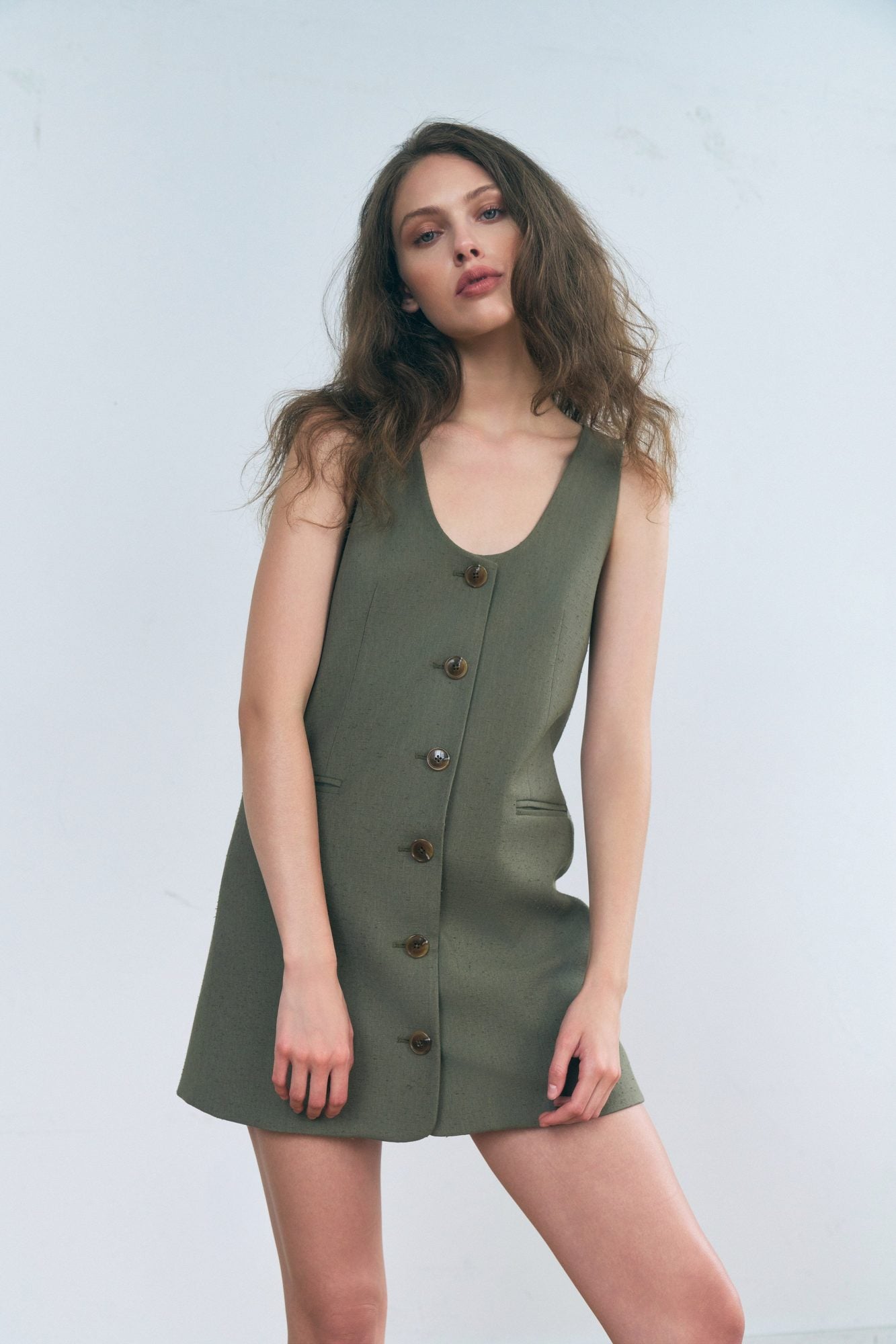 Stathe Malva Dress in Smoked Olive — front view, hand in pocket