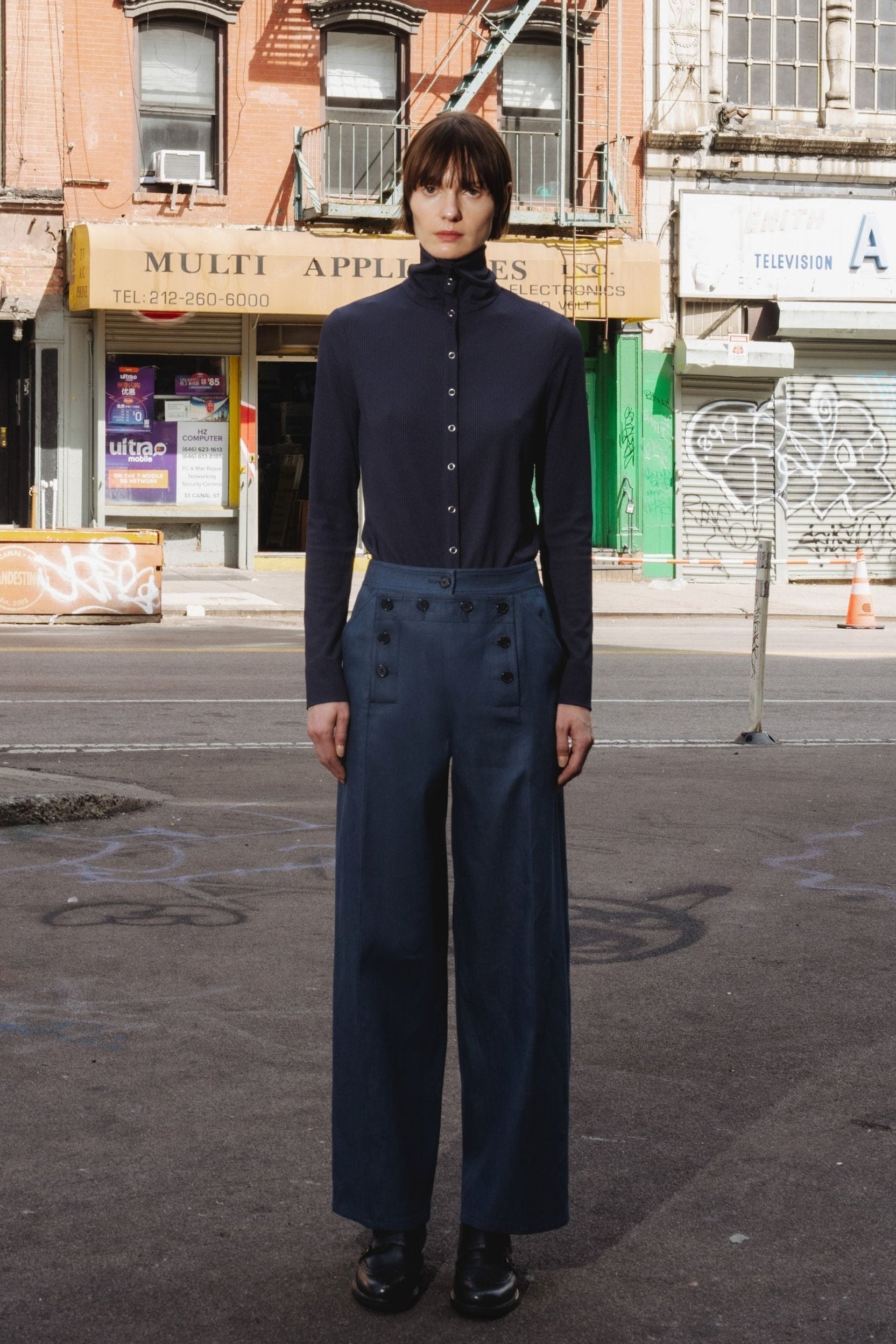 Papelillo ribbed top in Midnight — ultra-sleek ribbed jersey, metal snap buttons full length, wearable as turtleneck or open collar, easy relaxed fit, front view