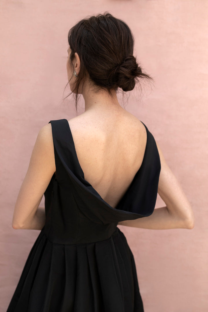 Pitahaya dress in Black — faille fabric, cowl back detail, full skirt above-ankle length, self-lined bodice, fully silk-lined skirt, hidden pockets, concealed side zip, back view