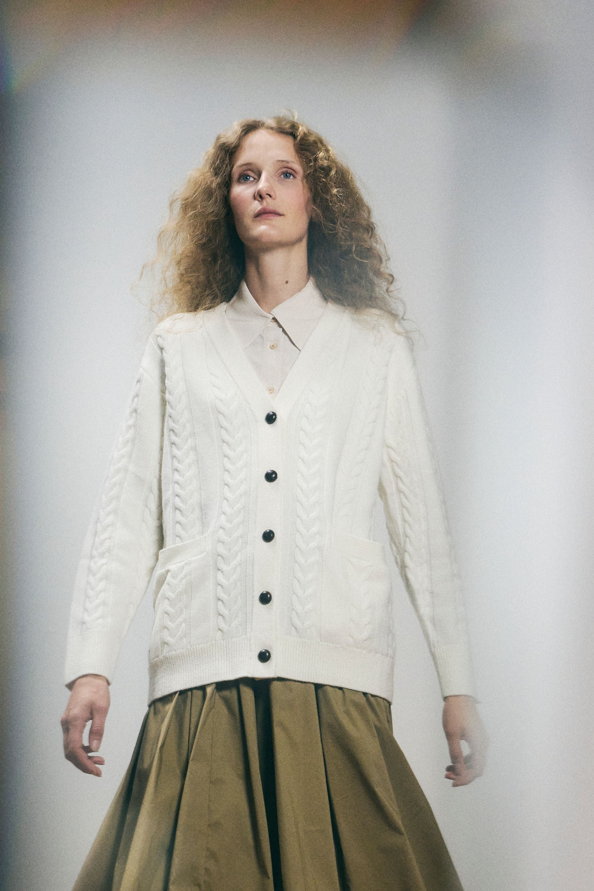 Sanmiguelito cardigan in Cream — 100% Extrafine Merino wool, horseshoe cable and rib knit pattern, dropped shoulder, ribbed cuffs and hem, dark brown leather buttons, below-waist length, back view