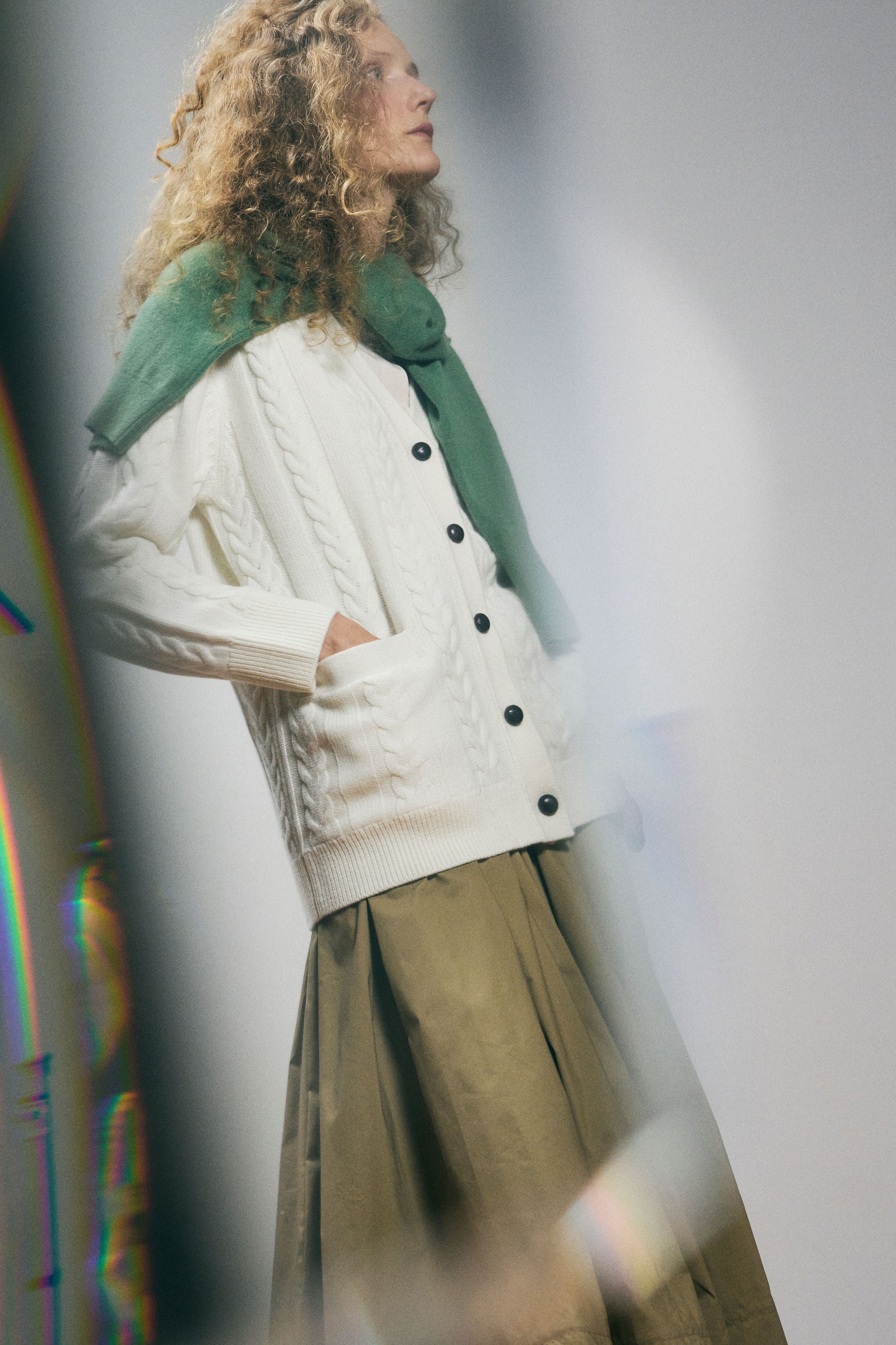 Sanmiguelito cardigan in Cream — 100% Extrafine Merino wool, horseshoe cable and rib knit pattern, dropped shoulder, ribbed cuffs and hem, dark brown leather buttons, below-waist length, lifestyle editorial