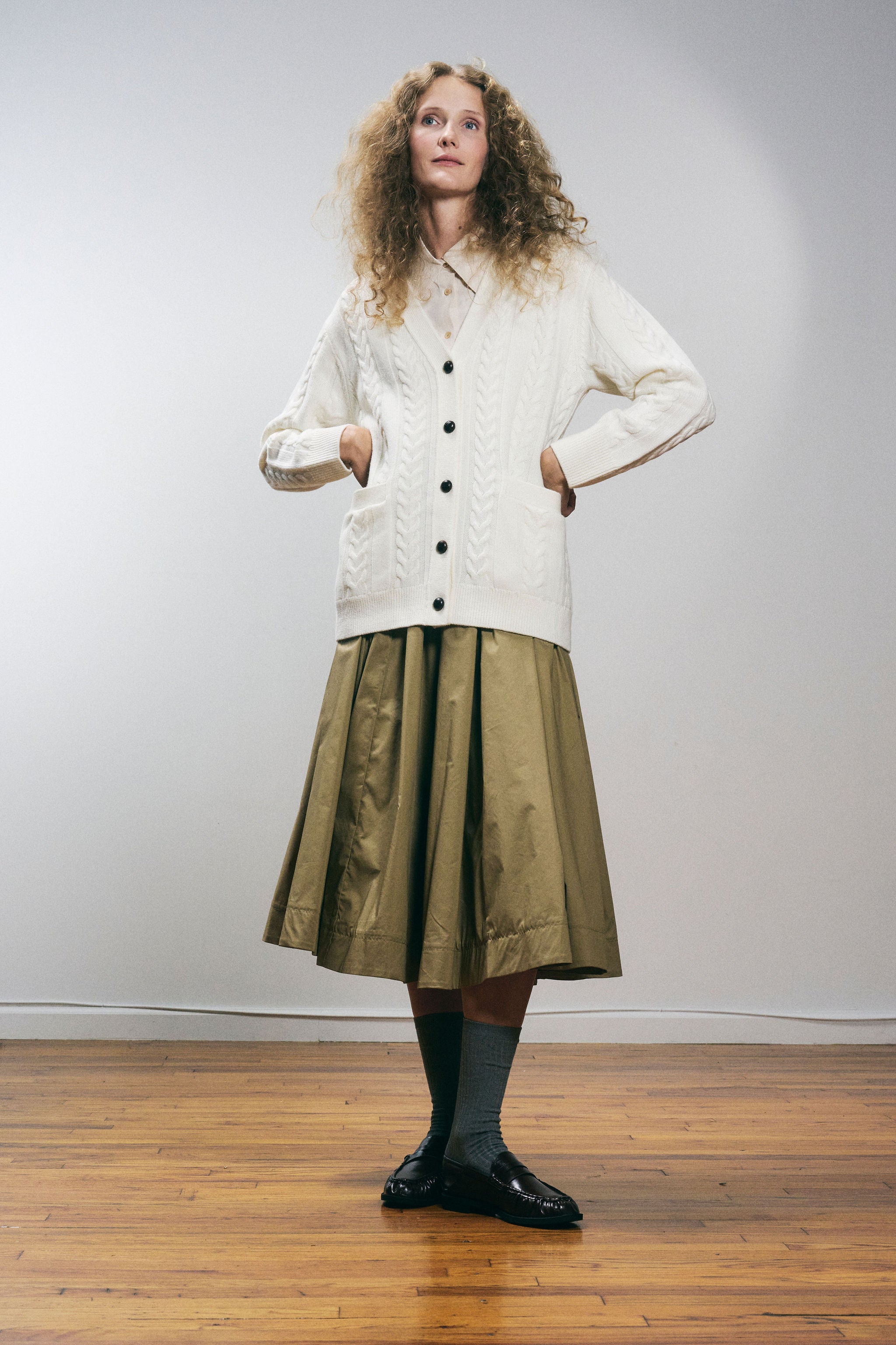 Sanmiguelito cardigan in Cream — 100% Extrafine Merino wool, horseshoe cable and rib knit pattern, dropped shoulder, ribbed cuffs and hem, dark brown leather buttons, below-waist length, side view