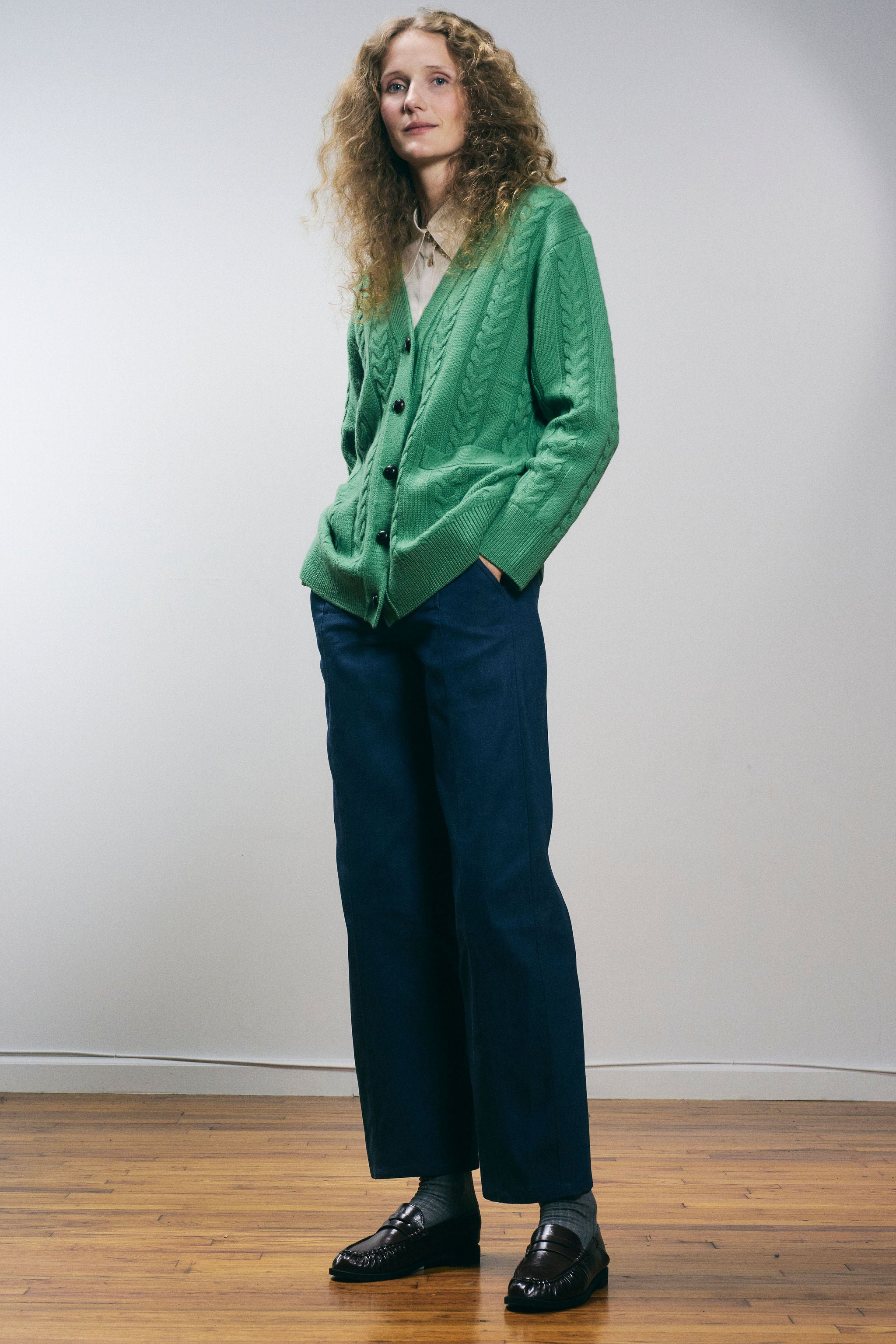Sanmiguelito cardigan in Green — 100% Extrafine Merino wool, horseshoe cable and rib knit pattern, dropped shoulder, ribbed cuffs and hem, dark brown leather buttons, below-waist length, side editorial