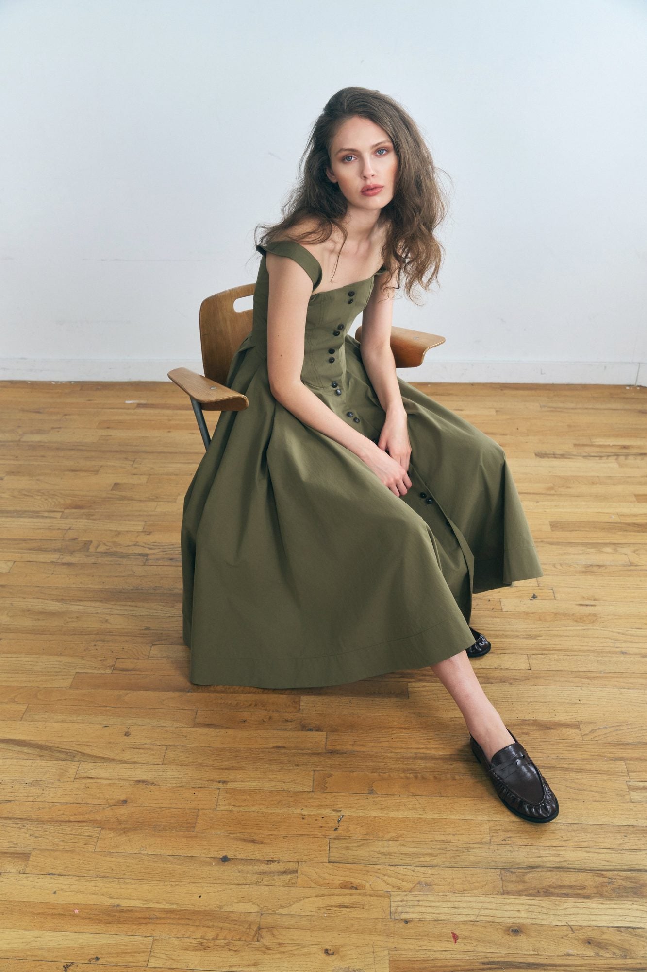 Woman wearing the Stathe Toloache Dress in Mosswood, seated — editorial