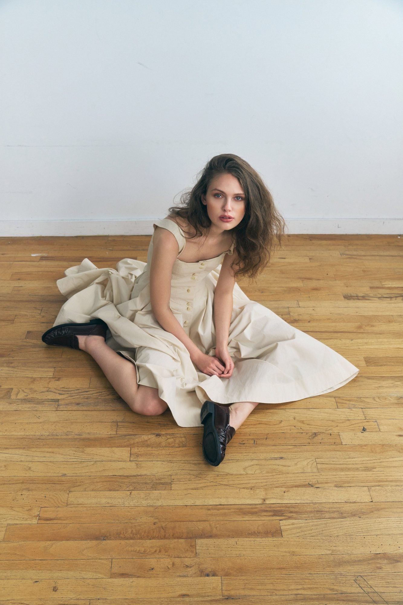 Woman wearing the Stathe Toloache Dress in Powder, seated — editorial
