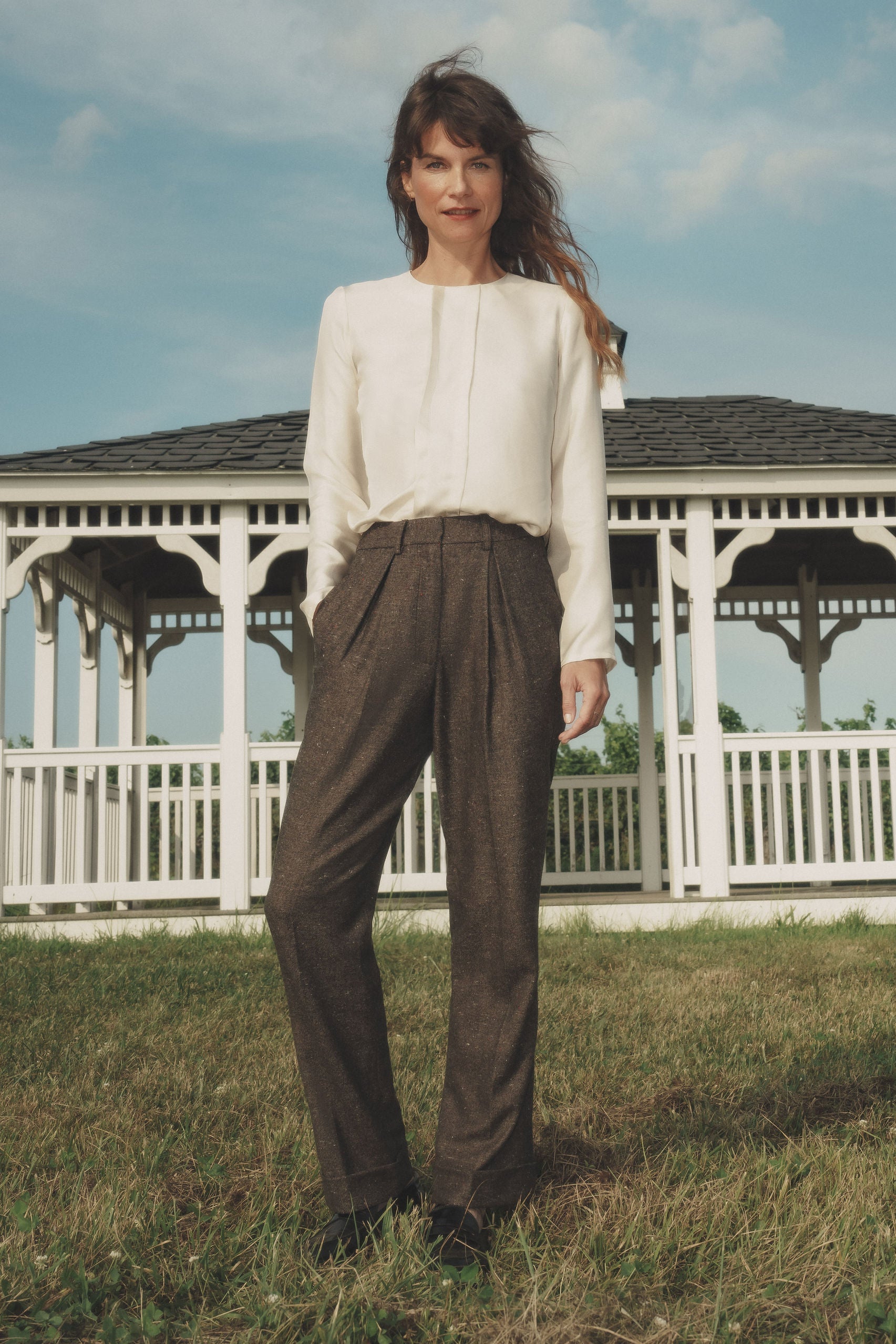 Torote Pants in Speckled Truffle — Japanese lightweight wool viscose, speckled tweed texture, 50's-inspired pleated silhouette, slightly tapered, cuffed hem, front hook and zip closure, lifestyle editorial